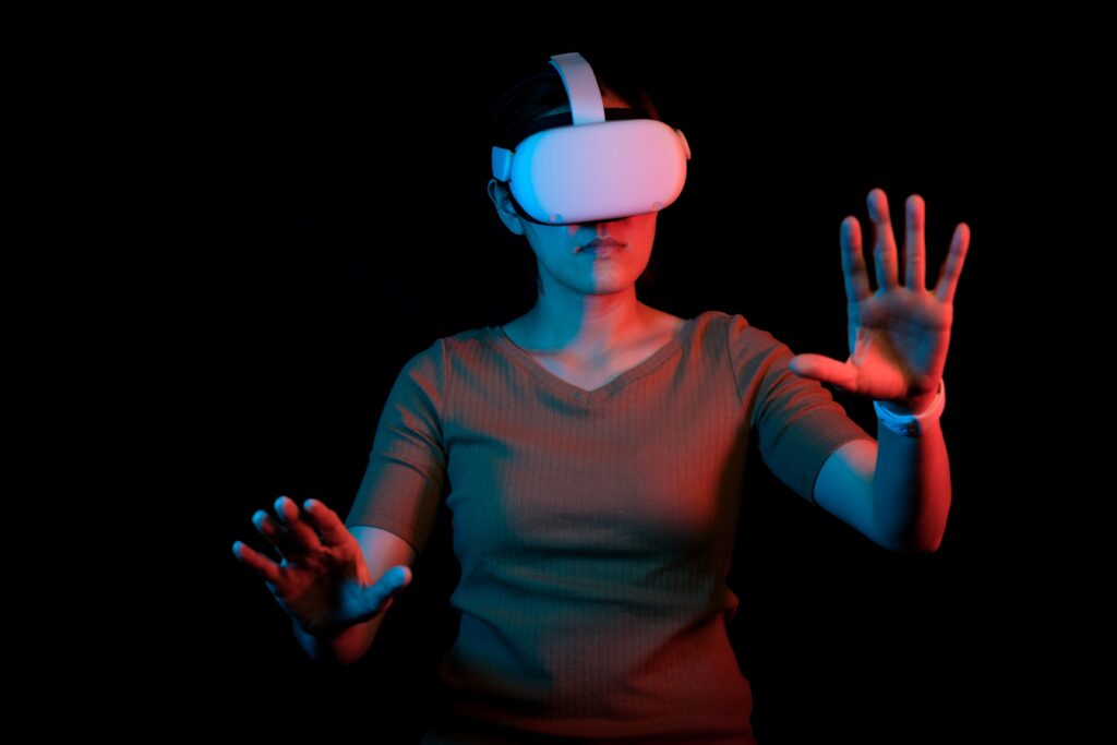 A student wearing virtual reality goggles, immersed in an interactive and immersive learning experience, waving their hands as they explore and engage with the virtual world at the University of Metaverse